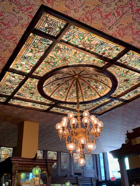 Ornate stained-glass ceiling and chandelier originally from Solomon's Apothecary, now at Gryphon Tea House